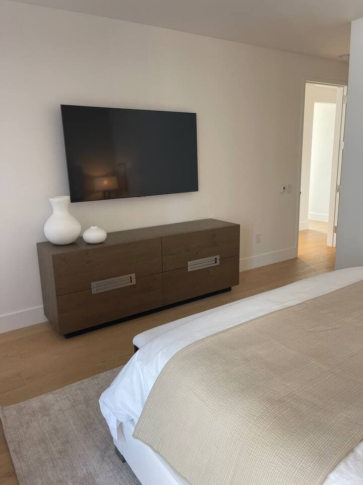 Primary bedroom with dresser and 65" Samsung smart TV